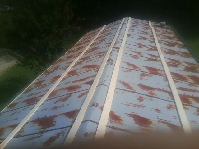 Rusted metal roof panels with new wood purlins before replacement — Storm Damage Roof Repair in Ballston Lake by Roofing Brothers