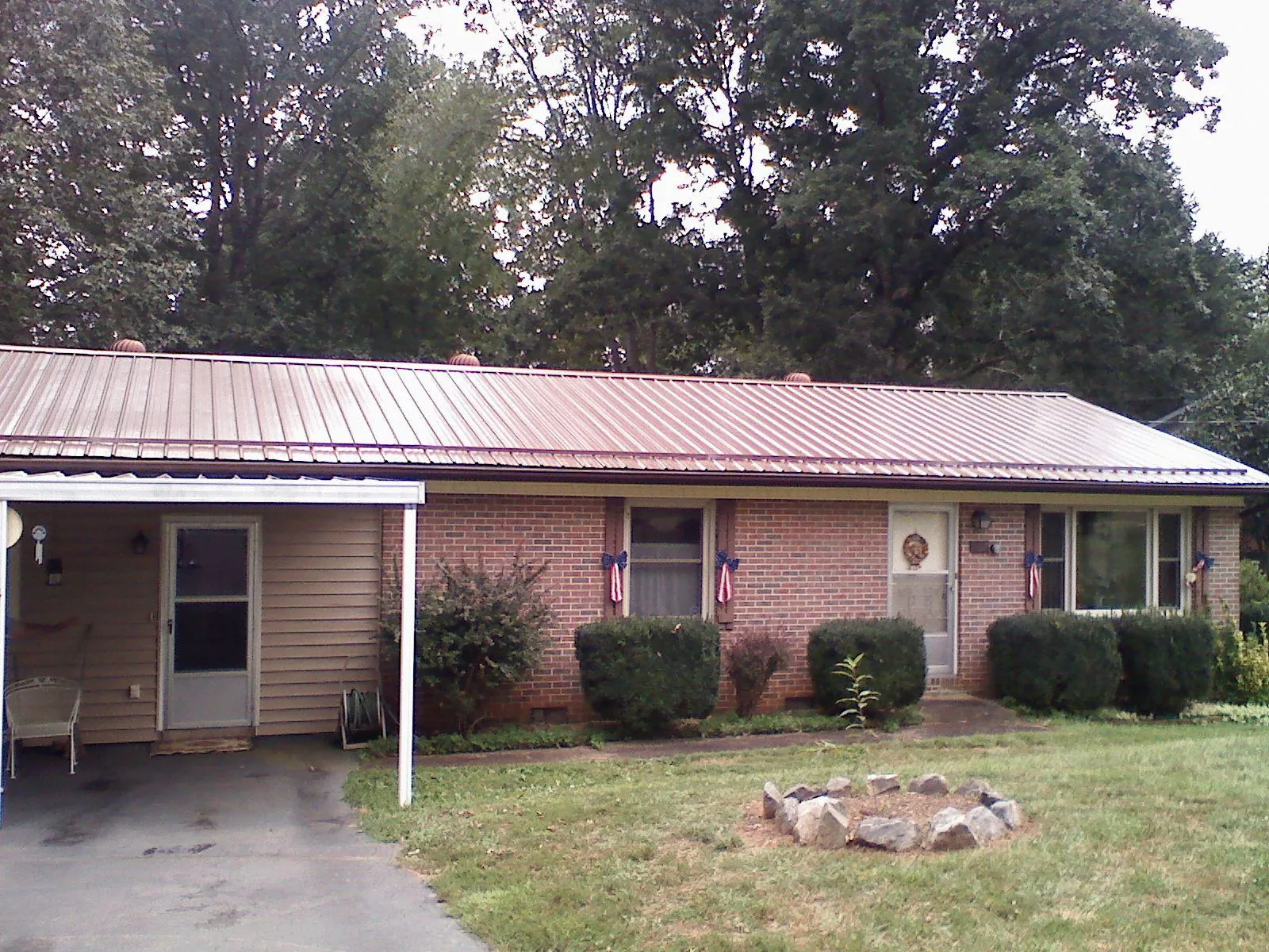 Bronze metal roof and carport on a brick ranch home — Roof Repair work by our crew in Ballston Lake